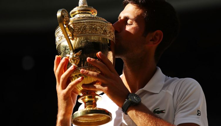 Novak Djokovic kisses his Wimbledon trophy
