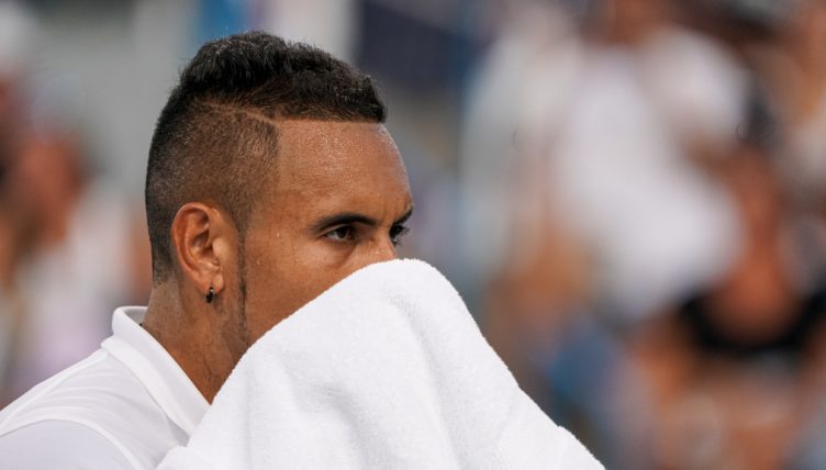 Nick Kyrgios wiping his face