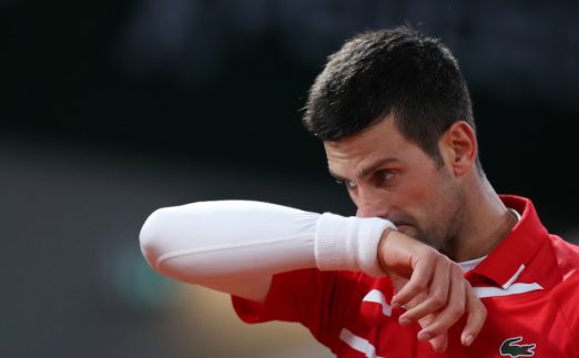 Novak Djokovic wiping his face