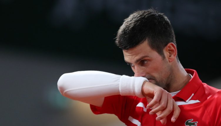 Novak Djokovic wiping his face