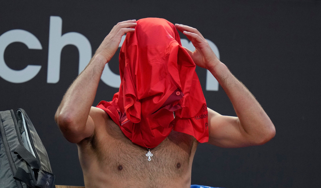 Novak Djokovic with his face covered