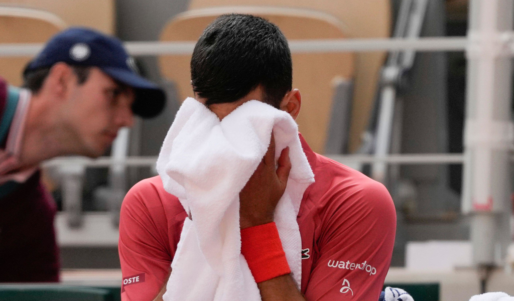 Novak Djokovic wipes his face