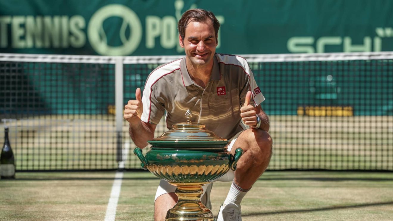 Halle, Germany. 23rd June, 2019. Tennis: ATP-Tour singles, men, final, Federer (Switzerland) - Goffin (Belgium). The winner Roger Federer kneels next to the trophy after the award ceremony and keeps his thumbs up