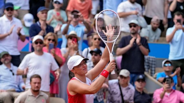 Iga Swiatek waves after winning an Olympic bronze medal
