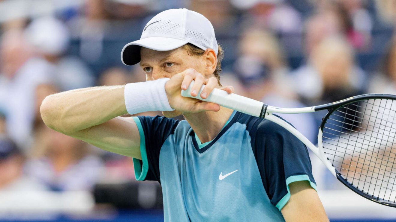 Jannik Sinner wipes his face