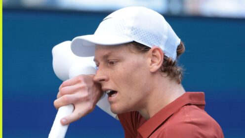 Jannik Sinner wipes his face during a match